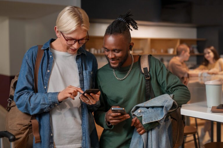 Two shop owners comparing search results on a phone while working out how to get your website found in Kenya