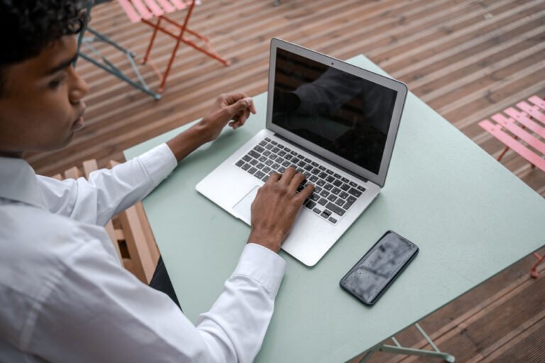 Phone and laptop open side by side to check a web designer's past work on live websites